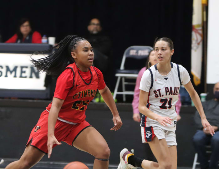 Aliyahna "Puff" Morris drives against St. Paul's Loretta Aguirre-Colmenero. Photo: John Murphy